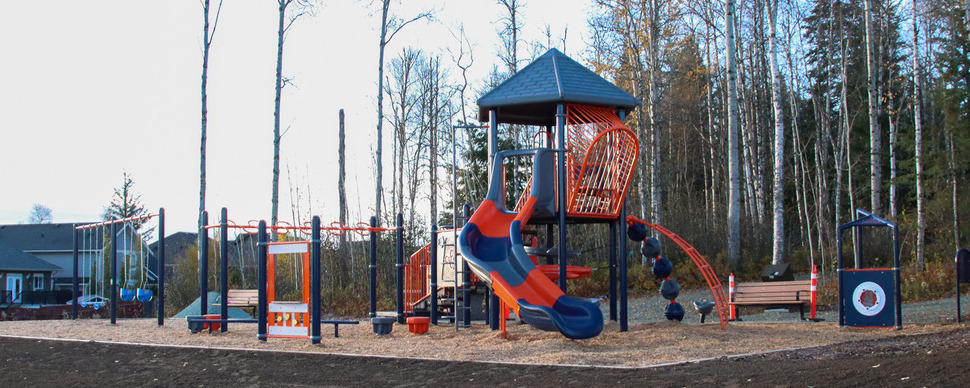 Blue and orange playground with climbing structures, a slide, balance beam, and swing set.